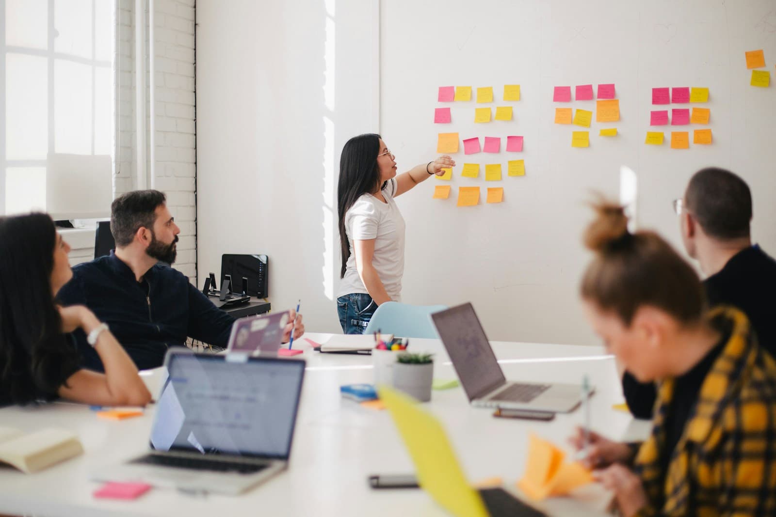 Team planning a product together at a whiteboard while colleagues collaborate